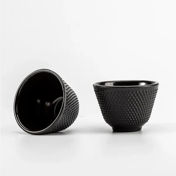 Pair of black cast iron tea cups